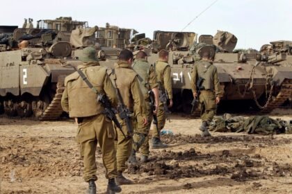 Junto a tanques do Exército de Israel, soldados israelenses circulam na fronteira com a Faixa de Gaza — Foto: Tsafrir Abayov/AP