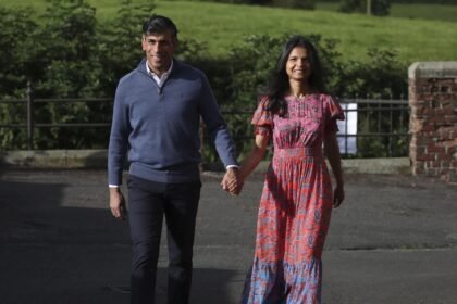 O primeiro-ministro britânico Rishi Sunak e sua esposa, Akshata Murty, caminham até um local de votação — Foto: Scott Heppell/AP