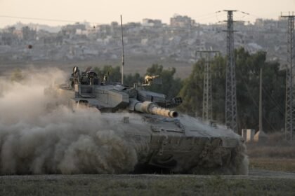 Soldado israelense acena de um tanque, perto da fronteira de Israel com a Faixa de Gaza — Foto: Tsafrir Abayov/AP